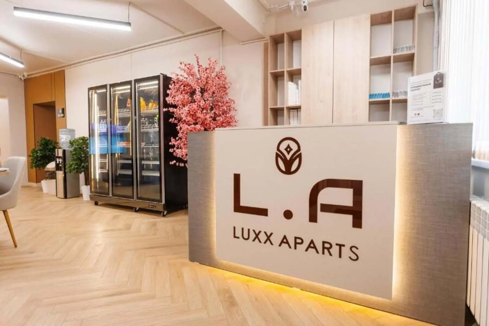 Стойка регистрации хостела Luxx Aparts с логотипом L.A, Алматы